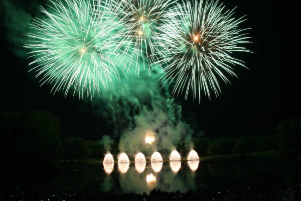 Langzeitbelichtung eines grünen Feuerwerks bei Nacht